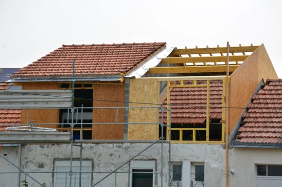 Chantier de construction résidentielle en extérieur avec maison en briques rouges partiellement achevée