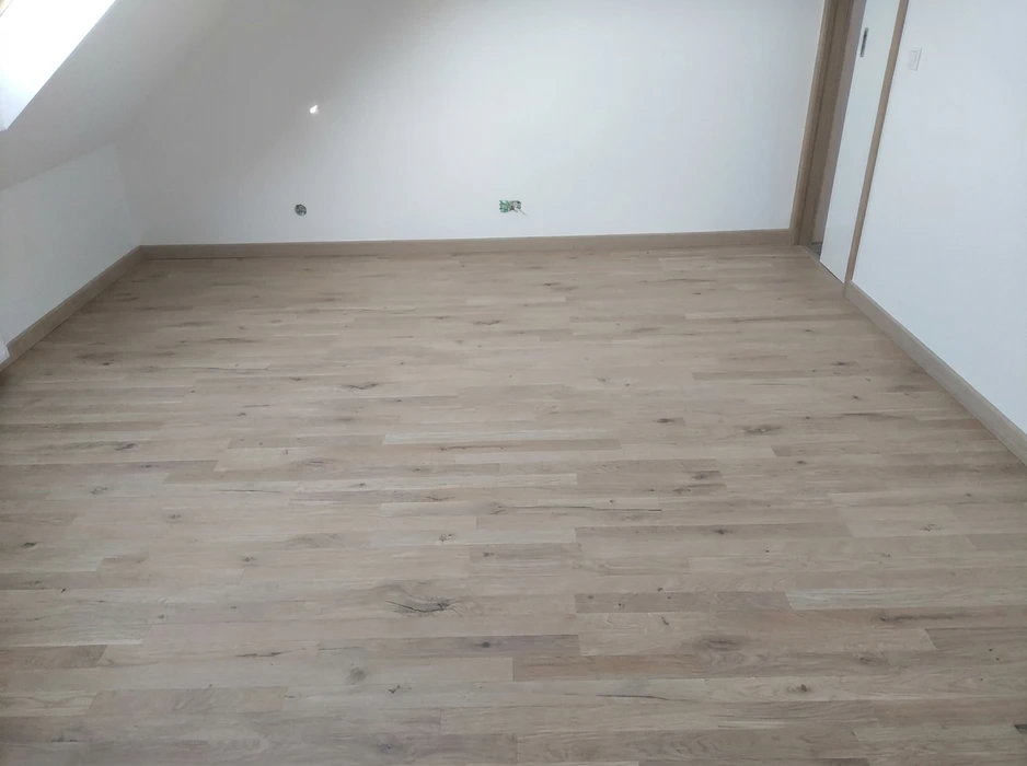 Sous-sol rénové moderne avec murs blancs et plafond à poutres apparentes